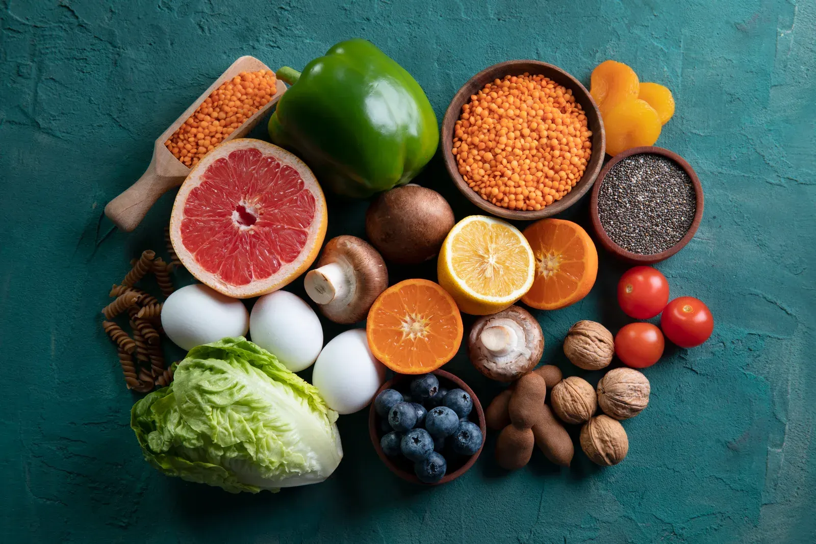 Varied selection of fiber rich foods on a teal background.