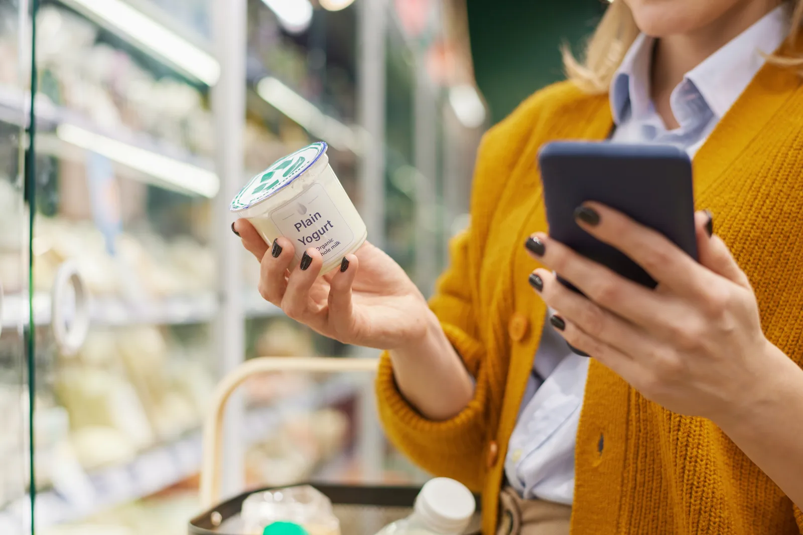 Lady reading the food label on a plain yogurt pot