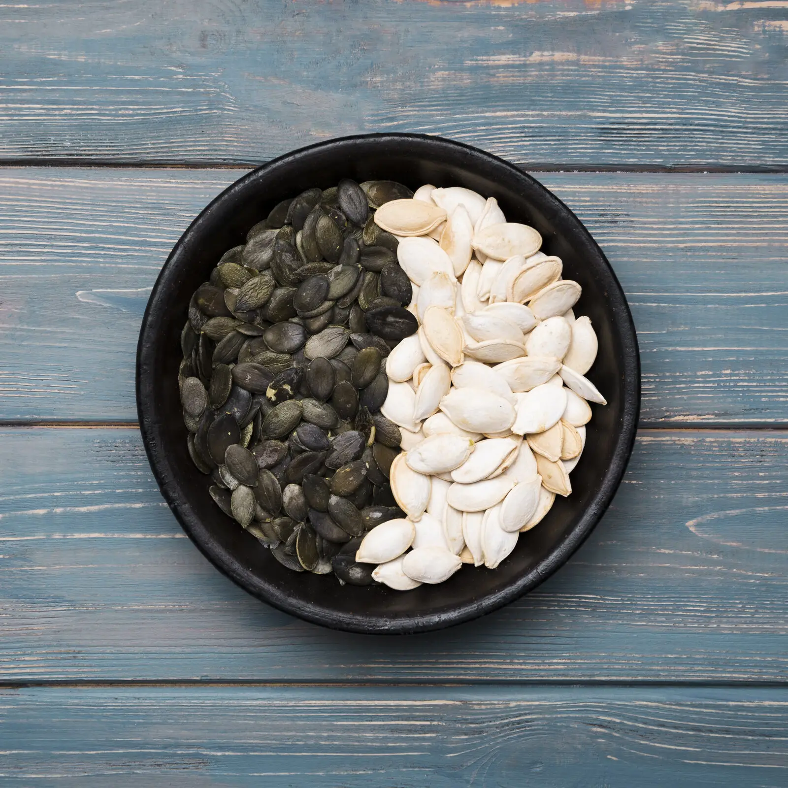 Pumpkin seeds laid flat on a wooden table